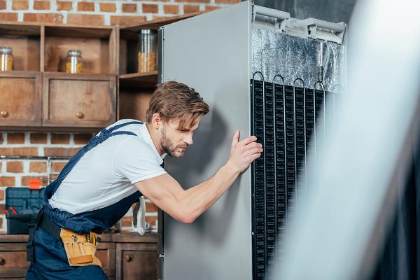 young-repairman-in-protective-workwear-moving-refr-resize.jpg